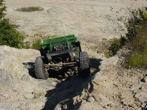 1992 Ford Bronco - Off-road vehicle navigates a challenging rocky terrain. Supermotors.net logo is present.