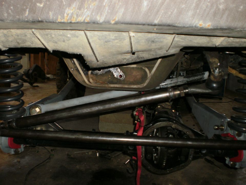 Underbody view of vehicle suspension with Supermotors.net logo