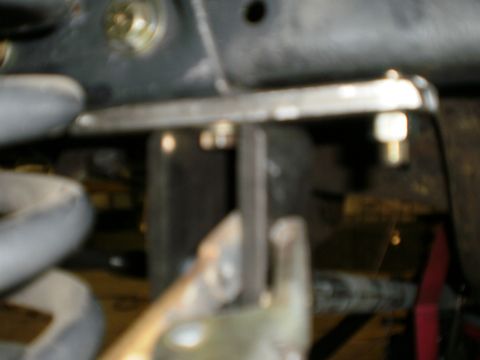 1995 Ford Bronco - This image shows a close-up view of vehicle suspension parts, including a coil spring and metal brackets.
