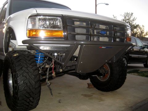 1996 Ford Bronco - Front view of a modified white Ford Bronco with aftermarket bumper and off-road tires.