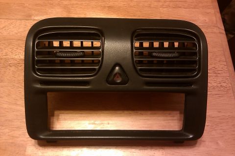 1997 Subaru Legacy - This black center dash vent and radio bezel assembly includes horizontal air vents and a hazard light button.