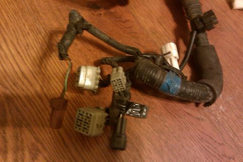 1997 Subaru Legacy - A collection of electrical connectors and wiring is laid out on a wooden surface.