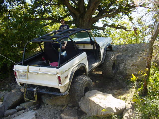 White off-road SUV with roll cage on rocks. Year 1978