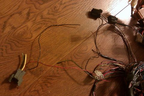 1997 Subaru Legacy - A collection of automotive electrical wiring and connectors are laid out on a wooden floor.