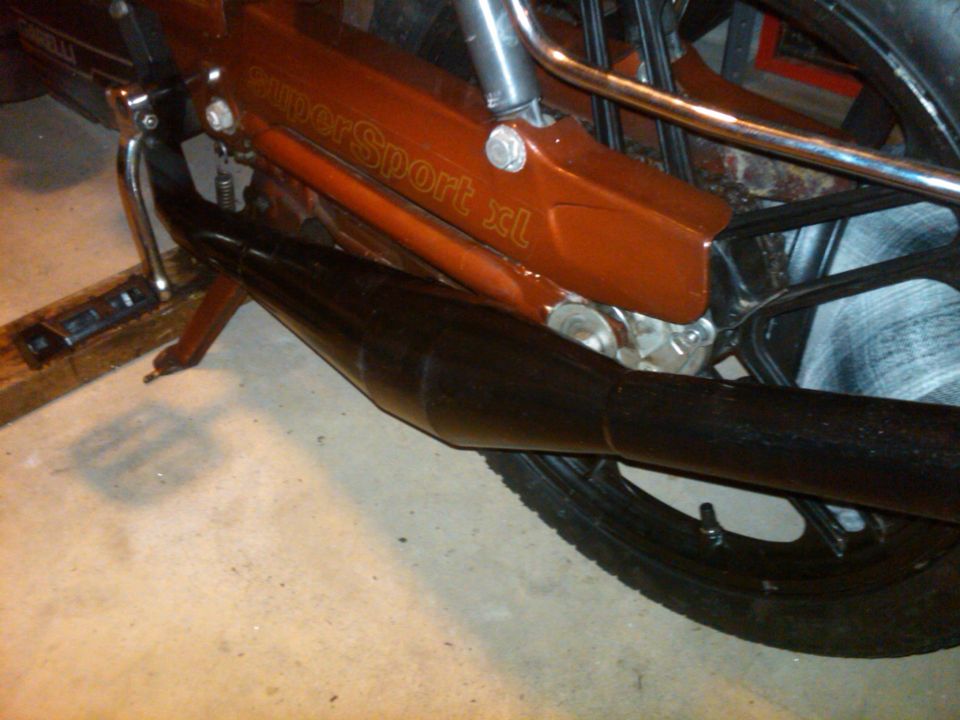 Close-up of a Garelli moped's orange frame with 'SuperSport xl' text and a black exhaust pipe