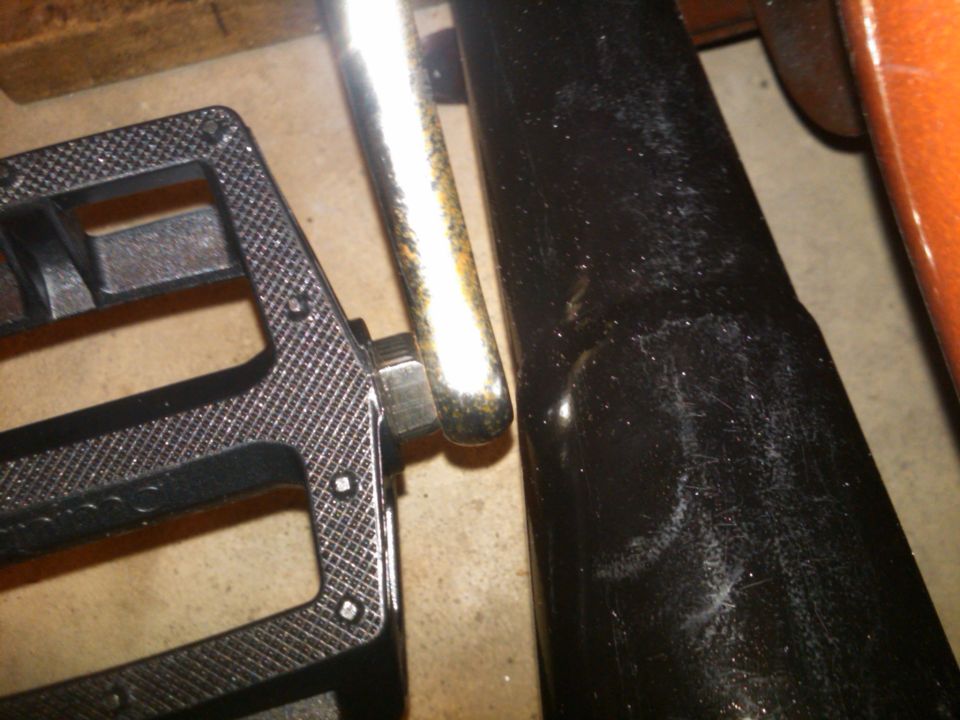 Black exhaust pipe next to a textured black pedal