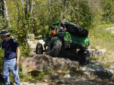 1992 Ford Bronco - This heavily modified off-road vehicle is shown navigating a challenging rocky trail.
