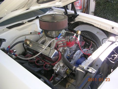 1972 Ford Ranchero - The engine bay of a white vehicle shows a V8 engine with performance modifications and a visible date stamp.