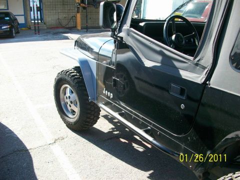 1992 Jeep Wrangler - Side view of a 1992 Jeep Wrangler with aftermarket side steps and fender flares.