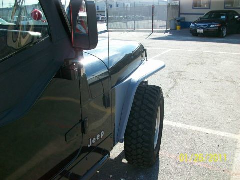 1992 Jeep Wrangler - Side view of a black Jeep Wrangler, aftermarket tube fenders and visible "Jeep" badging.