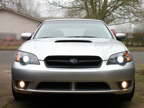2006 Subaru Legacy - The front of a silver Subaru sedan is shown with its headlights and fog lights illuminated.