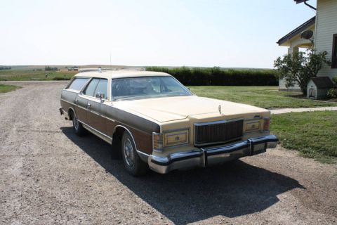1978 Mercury Colony Park - This station wagon, likely a 1978 Mercury Colony Park, is parked on a gravel drive in front of a rural house.