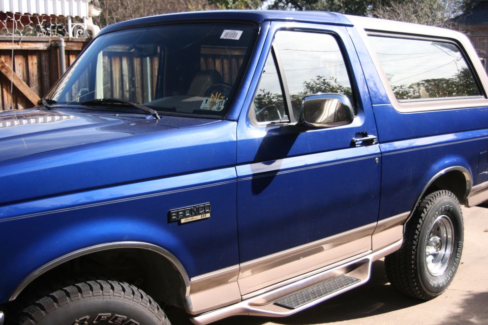 1996 Ford Bronco, blue with tan trim, side view showing running boards and fender flares