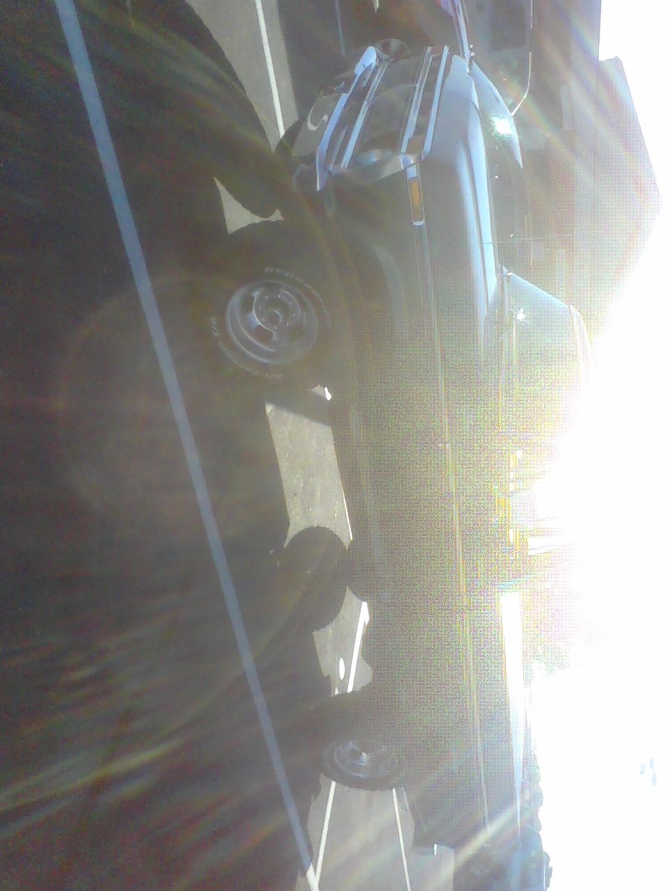 Dark SUV with chrome wheels and BFGoodrich tires, seen from the side