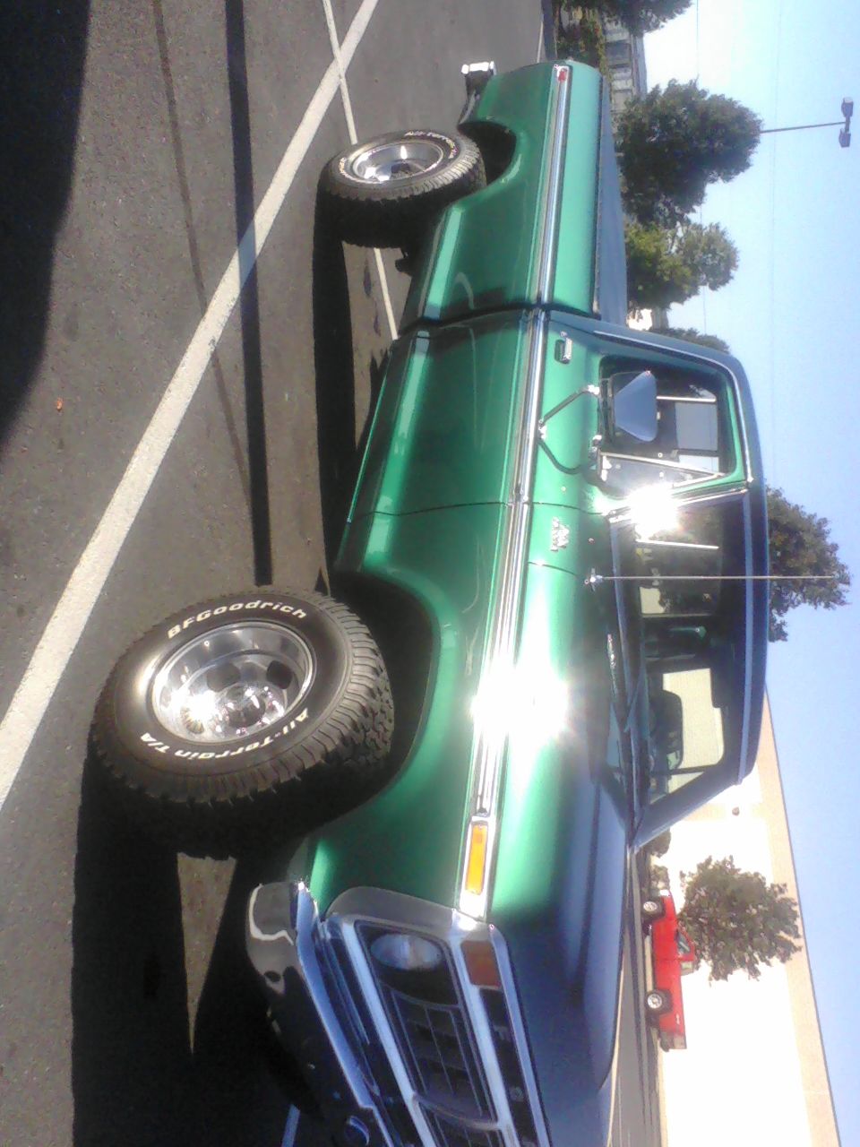 Green 1977 Ford F-150 pickup truck parked in a lot, side view