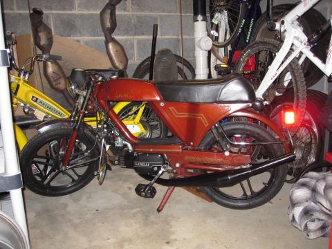 1981 Garelli Rally Sport - A red 1981 Garelli Rally Sport moped is parked in a garage next to a yellow Motobecane and bicycles.