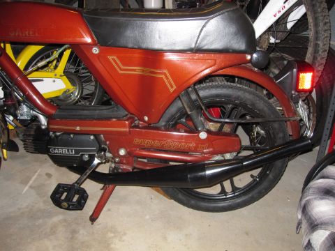 1981 Garelli Rally Sport - A red Garelli moped is parked indoors next to bicycles.