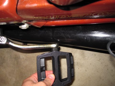 1981 Garelli Rally Sport - Close-up view of a motorcycle's exhaust pipe and a pedal, with a SuperMotors watermark visible.
