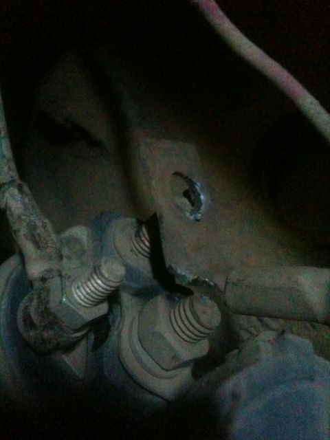 1993 Ford Bronco - This image shows a close-up view of rusty suspension components, including bolts and brackets, on a vehicle.