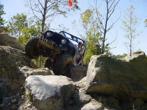 1992 Ford Bronco - A Jeep Wrangler navigates a challenging rocky terrain during an off-road excursion.
