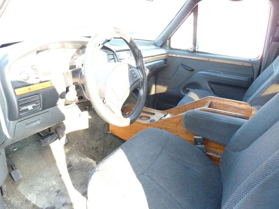 Interior view of a truck with wood trim and cloth seats
