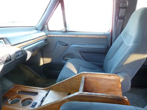 1993 Ford C-150 (Centurion Conversions) - Interior of a 1993 Ford C-150 (Centurion Conversions) with a custom wood center console and bucket seats.