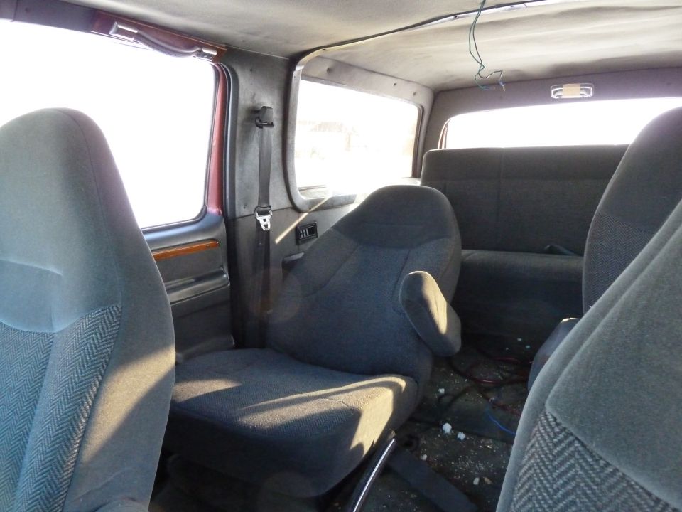 Interior view of a van showing front and rear seats, with a dirty floor