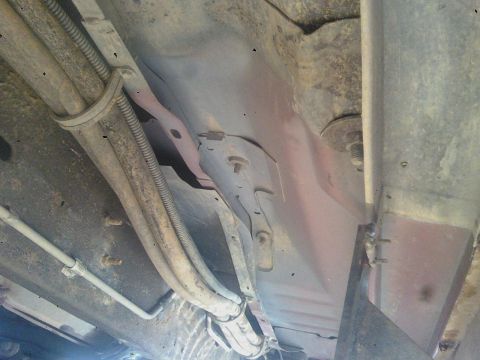 1993 Ford C-150 (Centurion Conversions) - The undercarriage of a vehicle, with visible fuel lines and structural elements.