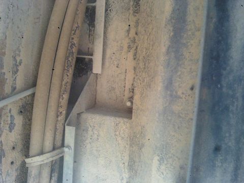 1993 Ford C-150 (Centurion Conversions) - Underside view of a vehicle showing various mechanical components and dirt accumulation.