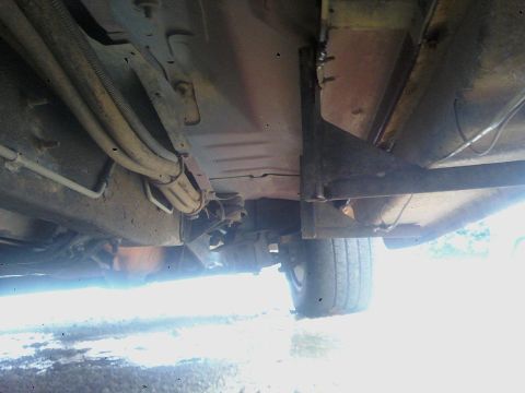 1993 Ford C-150 (Centurion Conversions) - The underside of a vehicle is visible, with focus on the frame and suspension components.