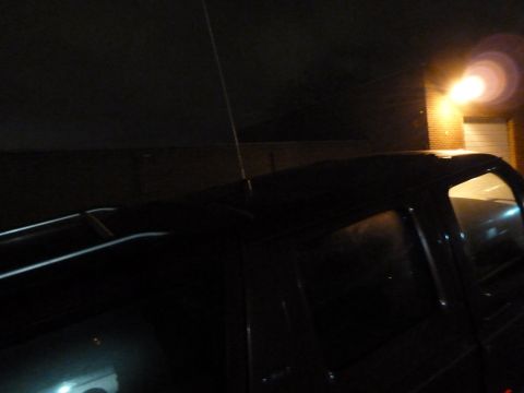 1993 Ford C-150 (Centurion Conversions) - A dark pickup truck is parked outside a building at night, illuminated by a nearby light.