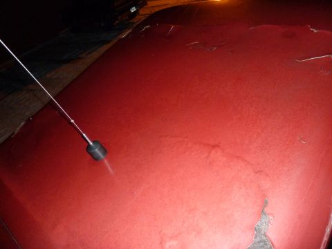 1993 Ford C-150 (Centurion Conversions) - Close-up of a red car hood showing wear and a radio antenna.