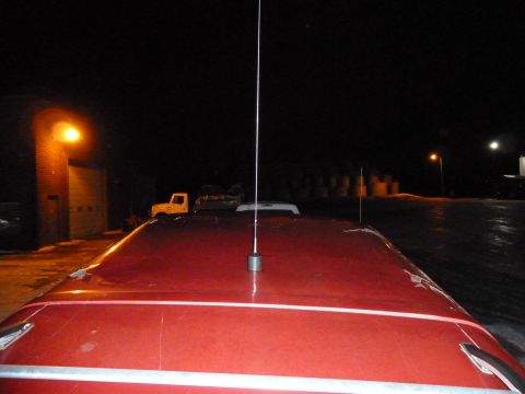 1993 Ford C-150 (Centurion Conversions) - A view of a red truck's roof at night, two antennas. A yellow truck is parked in the background.