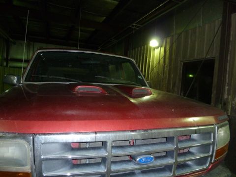 1993 Ford C-150 (Centurion Conversions) - Front view of a red Ford truck showing the hood and grille detail.