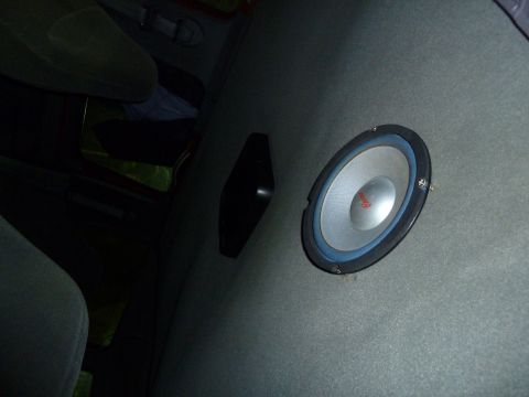 1993 Ford C-150 (Centurion Conversions) - A close-up of a car's interior shows a speaker mounted on a gray panel beside a seat.