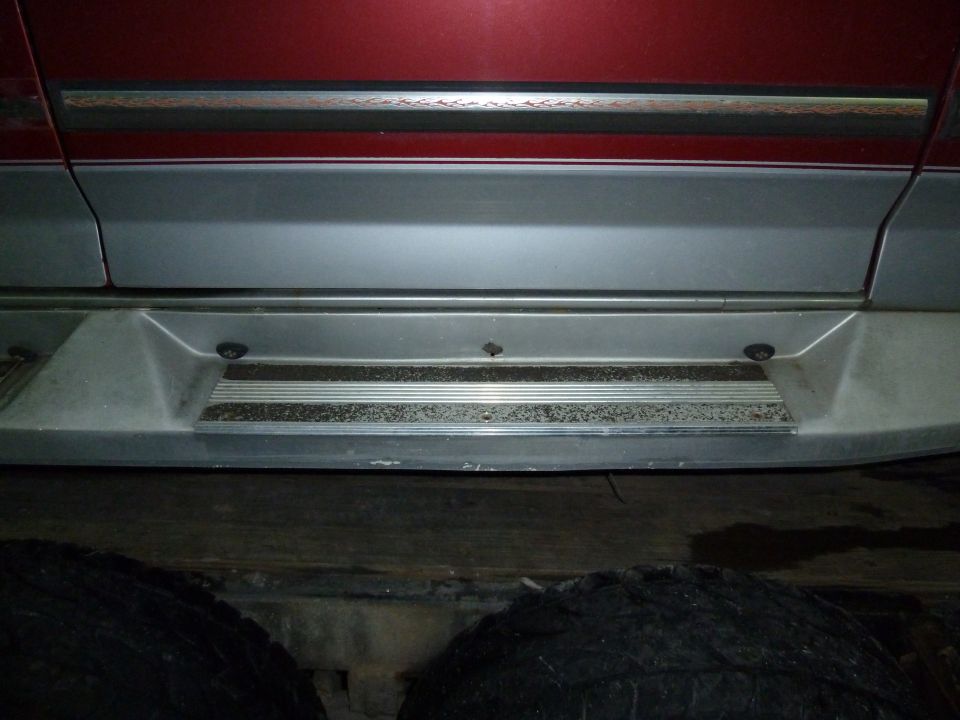 Side step and two-tone lower body panel of a vehicle, showing wear
