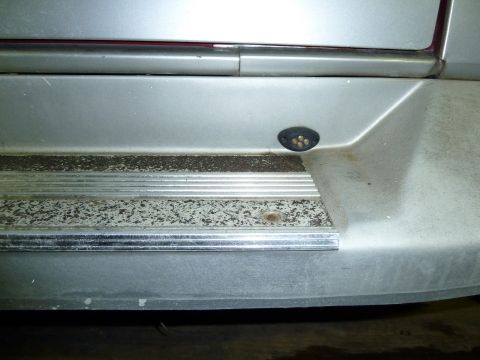 1993 Ford C-150 (Centurion Conversions) - The rear bumper step shows signs of wear and tear, with a small cluster of amber lights installed.