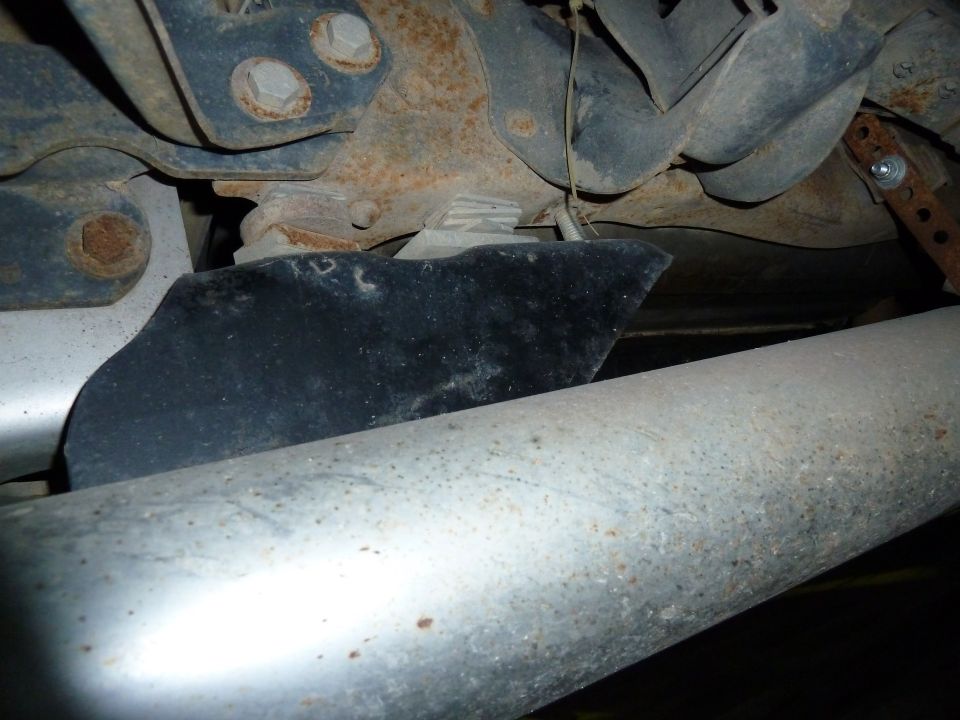Underside of a vehicle showing exhaust pipes and suspension components