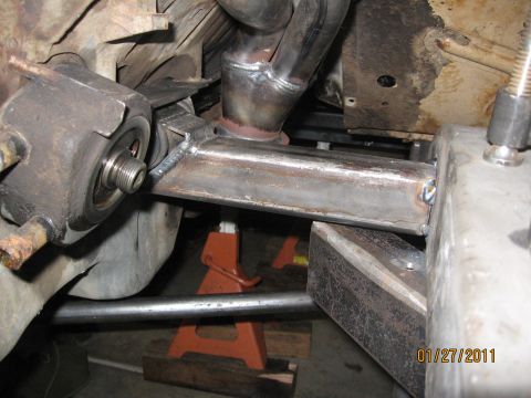 1961 International Scout 800 - Close-up view of custom fabricated exhaust and motor mount components on a vehicle frame.