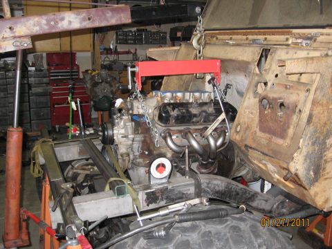 1961 International Scout 800 - Engine installation in progress, with a red engine hoist supporting the motor.