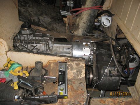 1961 International Scout 800 - Transmission and transfer case assembly shown with a red hose and a yellow doll.