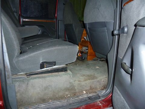 1993 Ford C-150 (Centurion Conversions) - The interior of a vehicle is shown, focusing on the rear seating area and the floor.