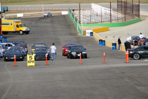 1995 Ford Taurus - A black 1995 Ford Taurus is parked on a race track with other vehicles.