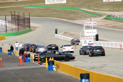 1995 Ford Taurus - Multiple vehicles are staged on a race track, with prominent Toyota branding in the background.