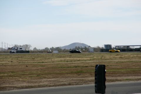 1995 Ford Taurus - Multiple vehicles on a race track with a mountain in the background.