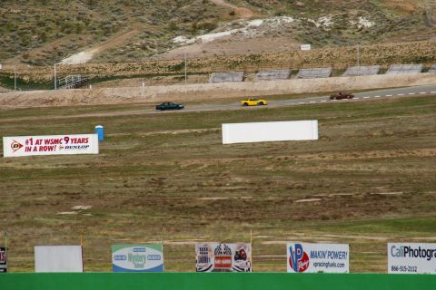 1995 Ford Taurus - Cars race on a track with advertising banners and spectators' stands visible.