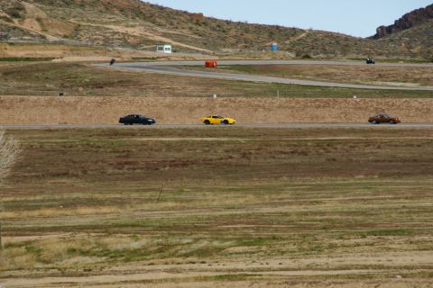 1995 Ford Taurus - Multiple vehicles are seen on a race track with a mountainous landscape in the background.