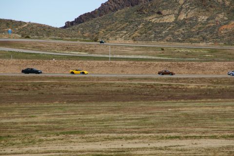 1995 Ford Taurus - Cars are seen driving on a track with a mountainous landscape in the background.