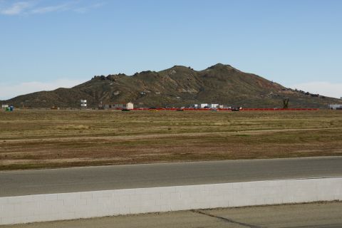 1995 Ford Taurus - View of a desert landscape with mountains and buildings in the distance, with a racetrack in the foreground.