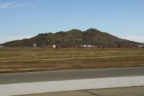 1995 Ford Taurus - A wide view of a mountain range with buildings and a racetrack in the foreground under a clear blue sky.